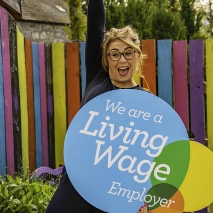 Female Living Wage worker jumping for joy